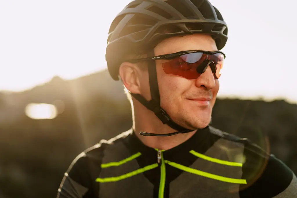 Retrato de ciclista masculino caucásico con casco y gafas de cerca